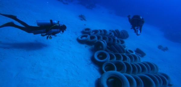 divers and car tires on the seabed